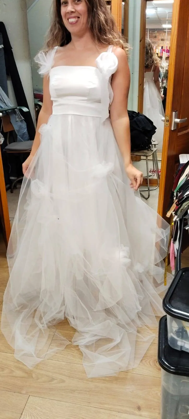 Happy bride wearing a white wedding gown during an Openfit fitting
