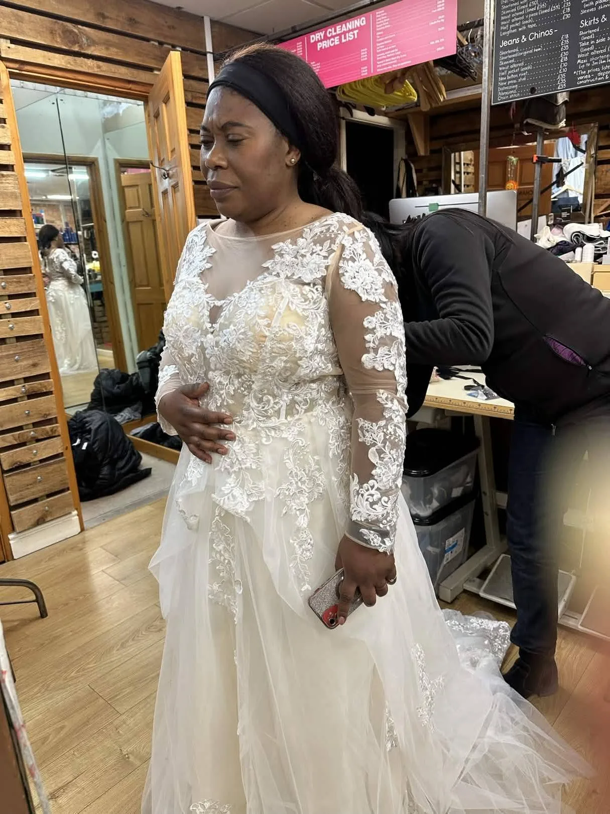 Bride wearing a long-sleeved lace wedding dress during an Openfit fitting