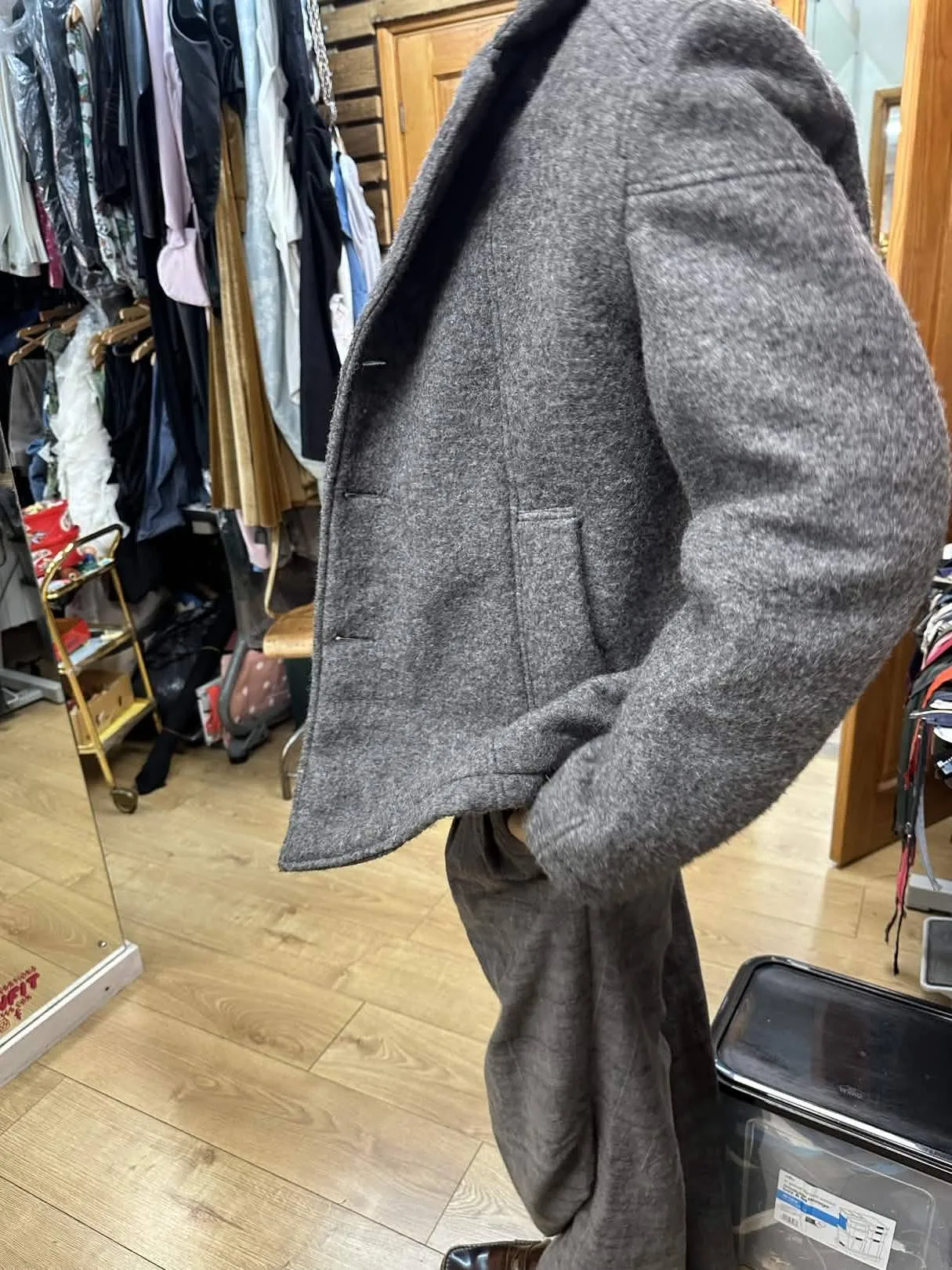 Grey wool jacket showing tailored pocket, sleeve and side-body construction