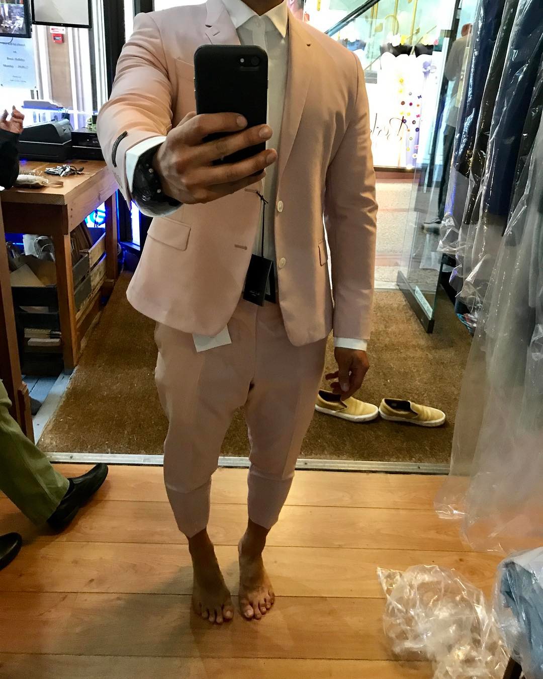 Person wearing a pale pink suit during a fitting
