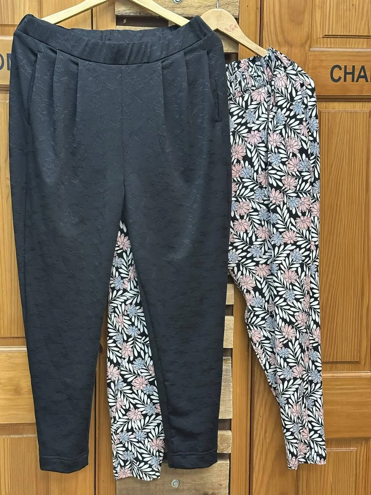Dark textured trousers and floral trousers showing different trouser shapes and finishes