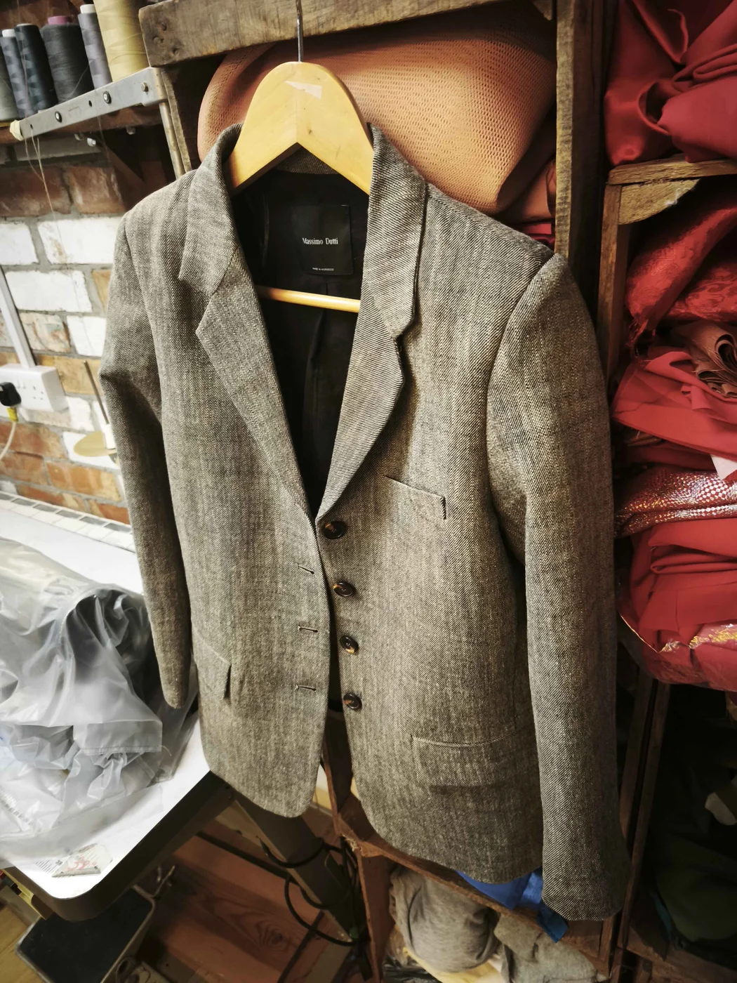 Grey tweed blazer showing lapels, button fastening, pockets and full-length sleeves